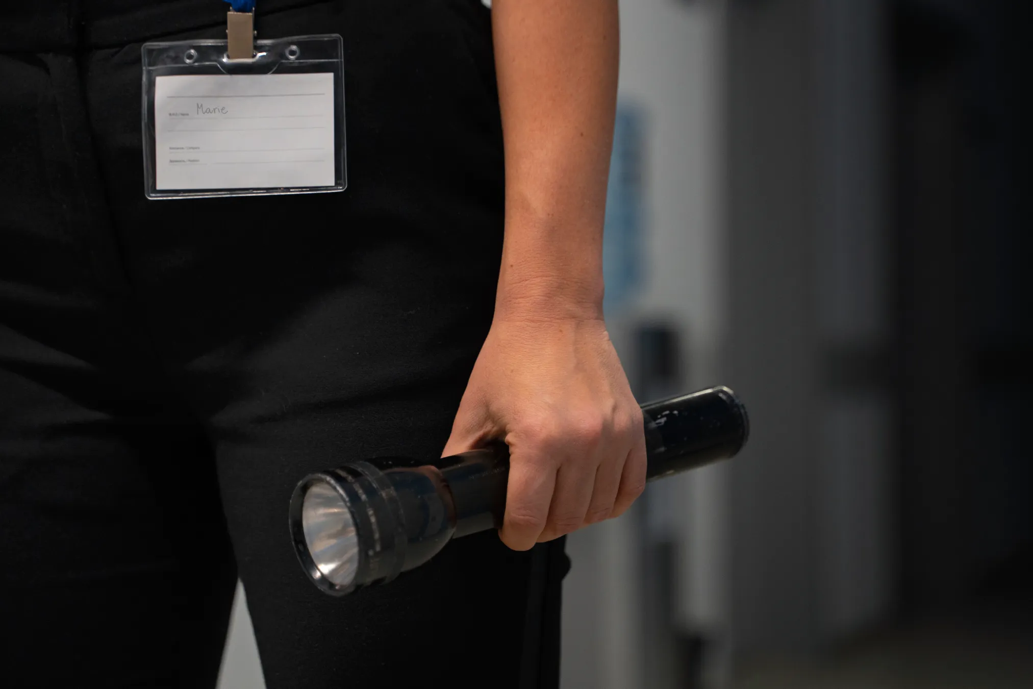 Security officer with an ID badge holding a torch